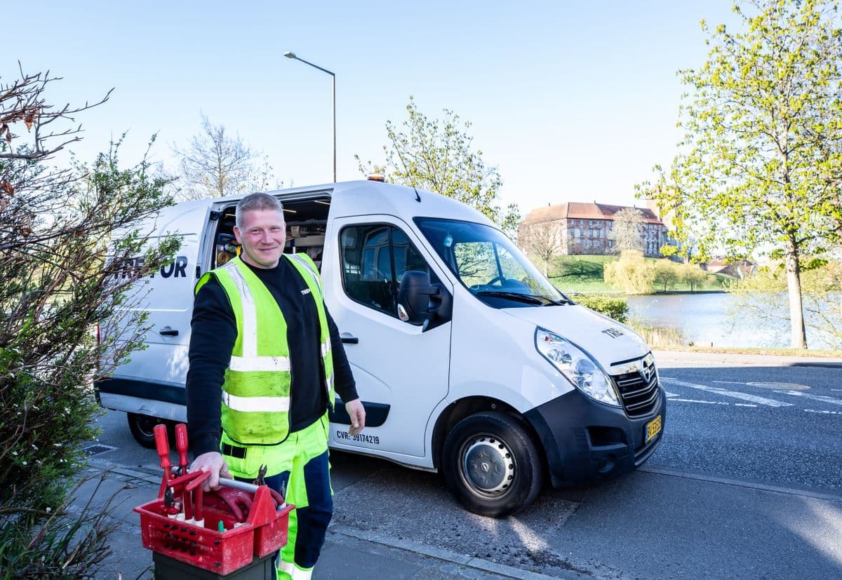Handwerker mit Werkzeug vor seinem Transporter